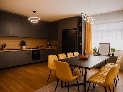 Bucătărie modernă închisă cu iluminare ambientală și scaune galbene