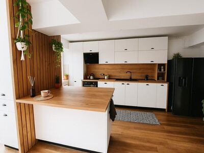 Bucătărie albă cu insulă și elemente din lemn natural