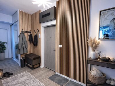 Cuier pentru hol cu riflaje din lemn, bancă și zonă decorativă modernă