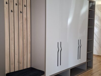 Mobilier de hol modern alb cu dulap mare, bancă și panou cu riflaje din lemn