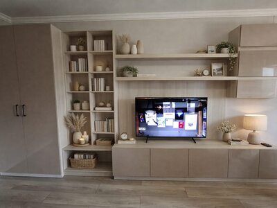 Mobilă living la comandă bej din lemn deschis cu bibliotecă înaltă, rafturi cu niveluri multiple și comodă TV cu uși